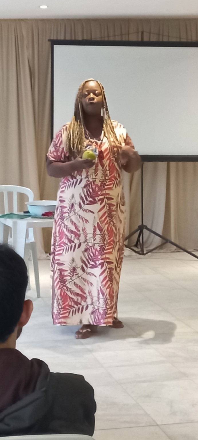 Luciane Osundaye apresentando uma maçã durante a vivência